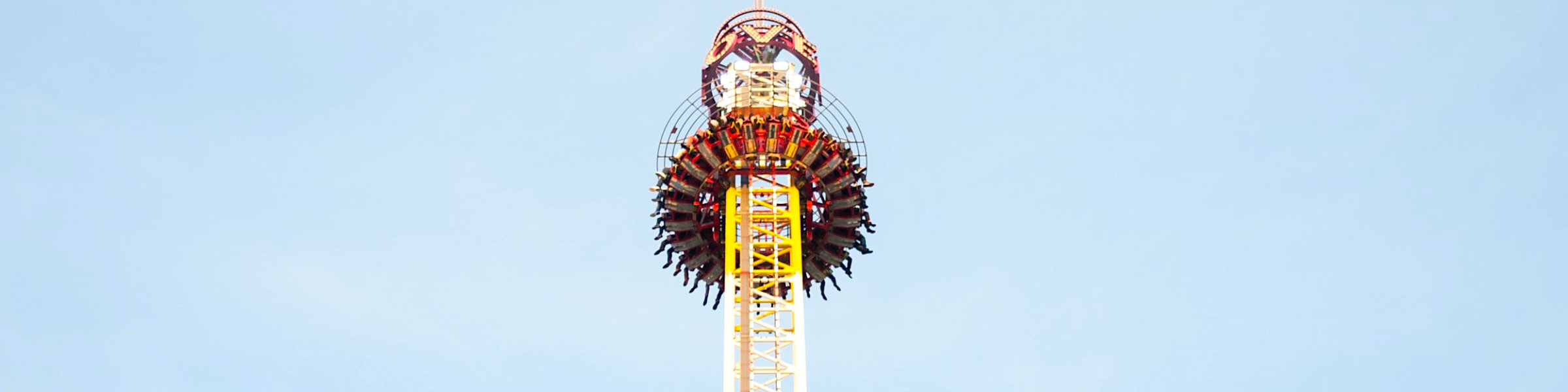 Free-Fall-Tower mit Fahrgästen von unten.