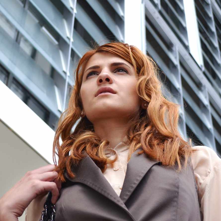 Junge Frau mit beobachtendem Blick in der City.