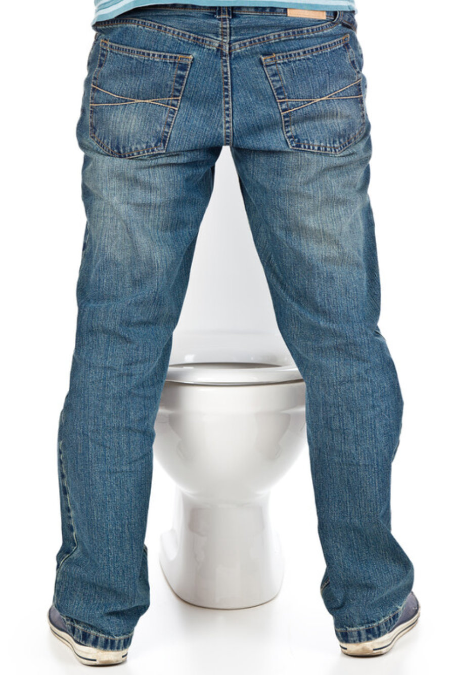 Mann pinkelt stehend in eine Toilette