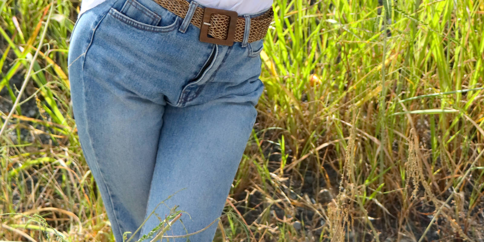 Abiturientin in Jeans kreuzt dringend pinkeln müssend ihre Beine.