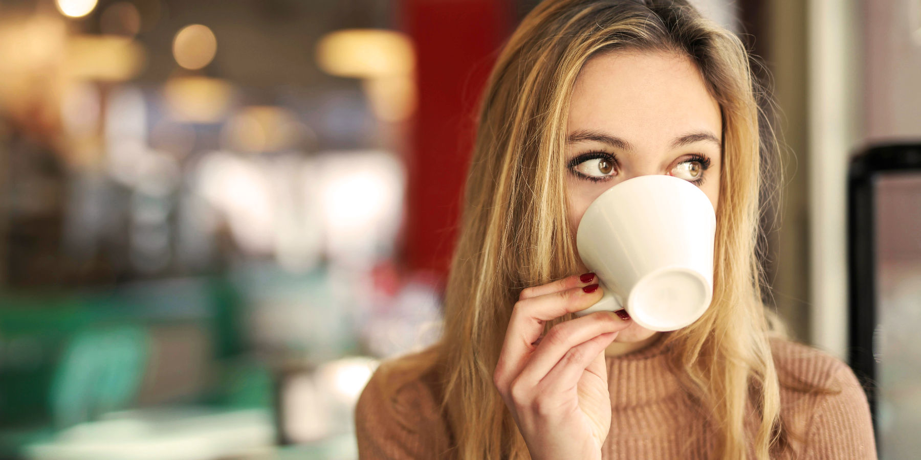 Symbolbild: Blonde Frau trinkt Kaffee.