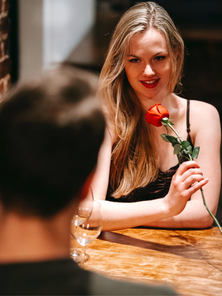 Blonde Frau mit Rose bei einem Date.