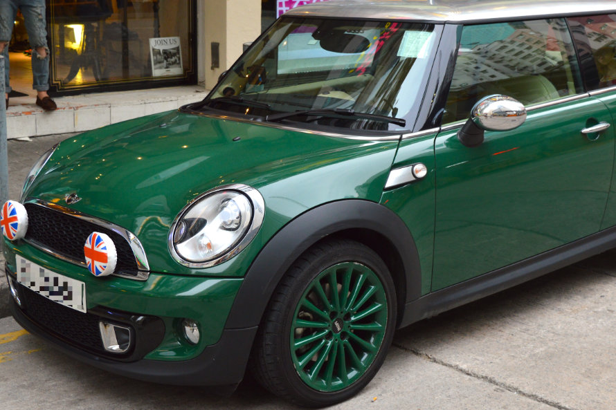 Grüner Mini Cooper parkt mitten in der Stadt am Straßenrand