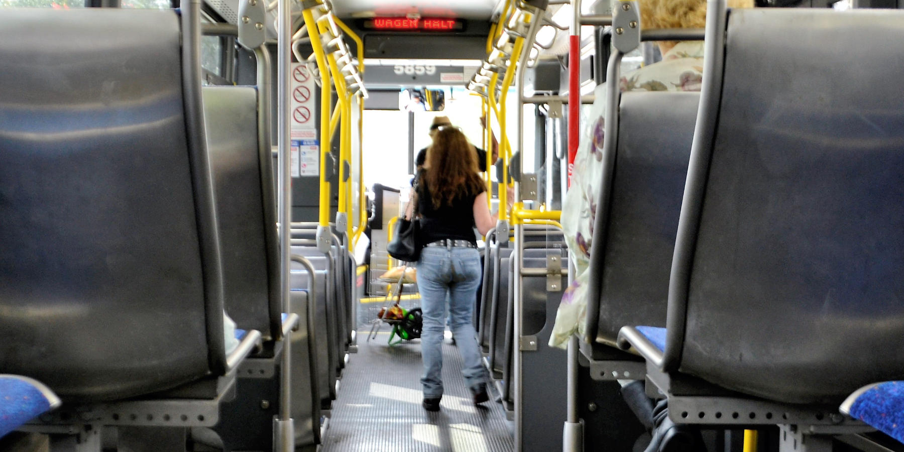 Junge Frau steht mit vollgemachter Hose im Bus.
