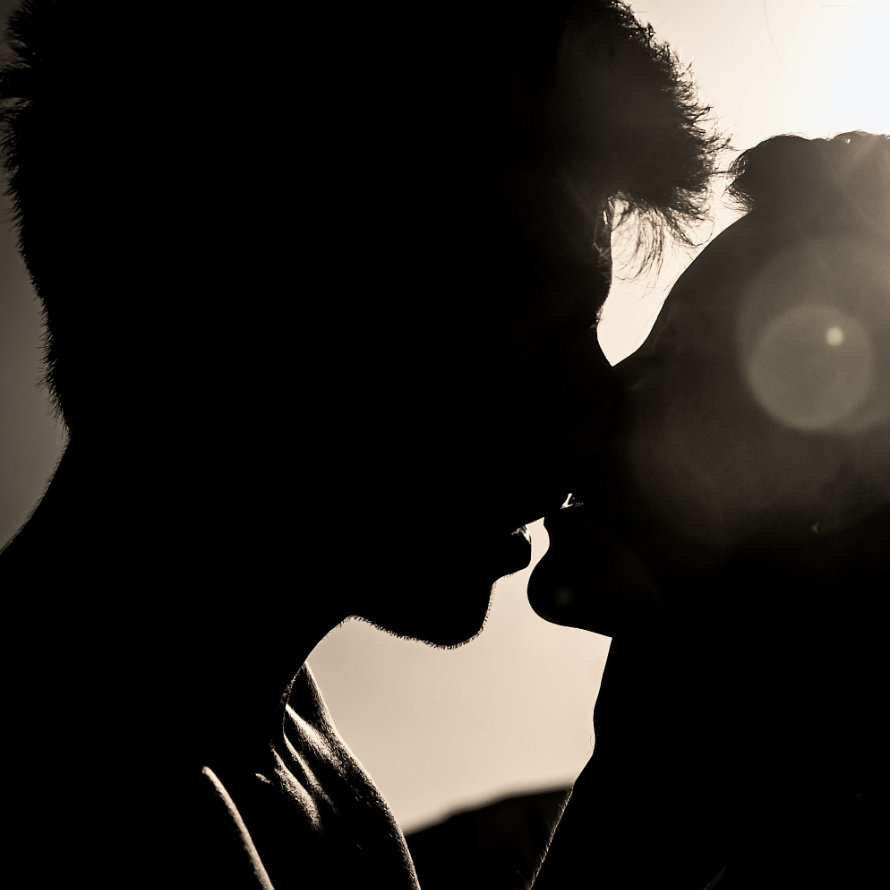 Frau und Mann küssen sich im Gegenlicht