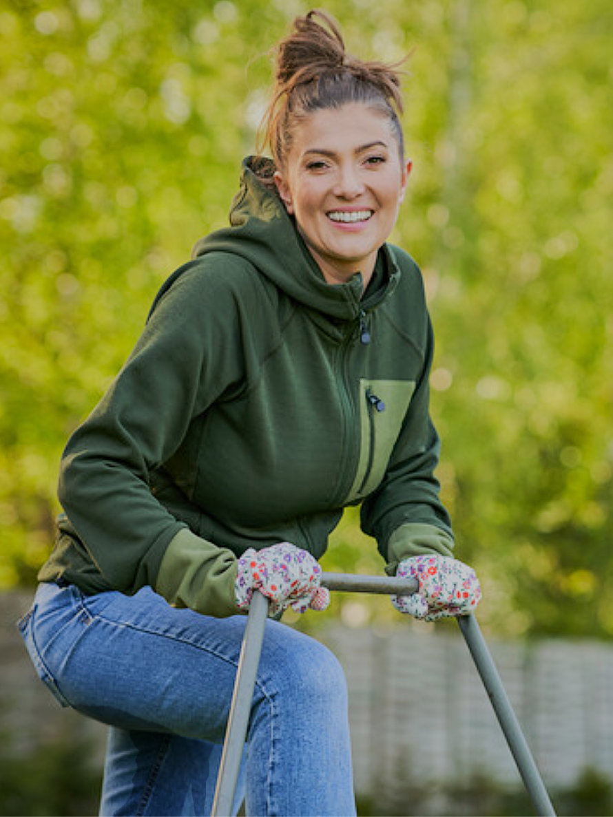 Frau in eingepinkelter Jeans nach dem Rasenmähen