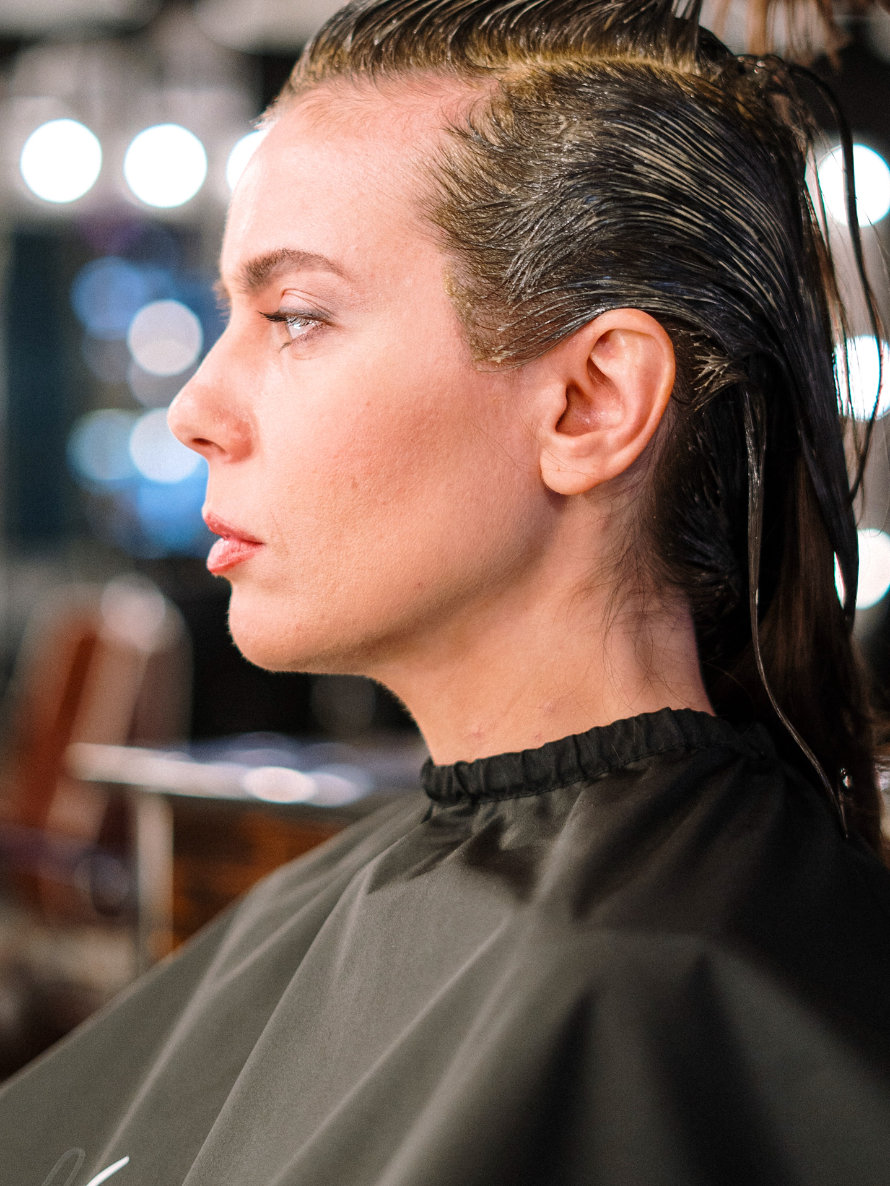 Frau sitzt dringend müssend beim Friseur