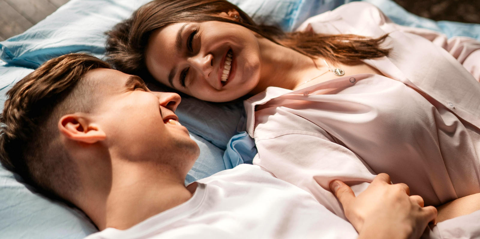Glückliches, junges Paar im Bett.