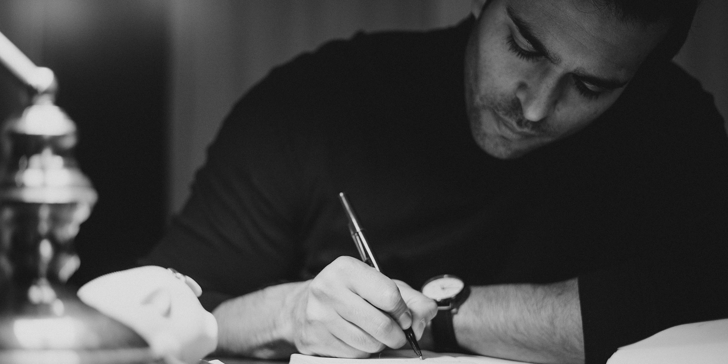 Junger Mann am Schreibtisch in seiner Arbeit vertieft